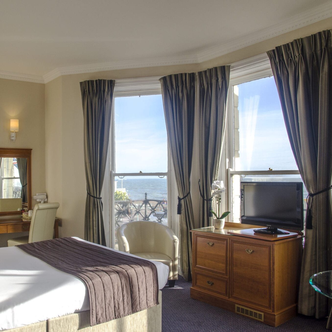 The Kings Hotel room, located by the seafront and furnished with a double bed, dressing table and television.